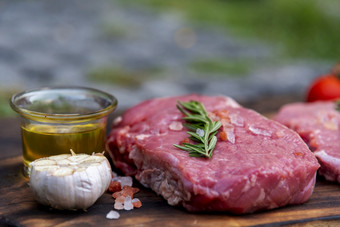 生肉牛肉牛排有机新鲜的成分木董事会表格背景厨房与迷迭香盐大蒜番茄黑色的胡椒橄榄石油肉牛肉木板为牛排生肉