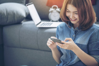 聪明的女人探索在线购物网站智能手机微笑脸亚洲女人持有手机与电子商务购物在线网站阅读在线文章博客和视频博客