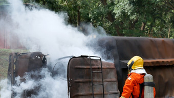 消防队员战斗与火焰使用火软管化学水泡沫喷雾引擎消防队员穿硬他身体安全西装统一的为保护救援培训火战斗灭火器