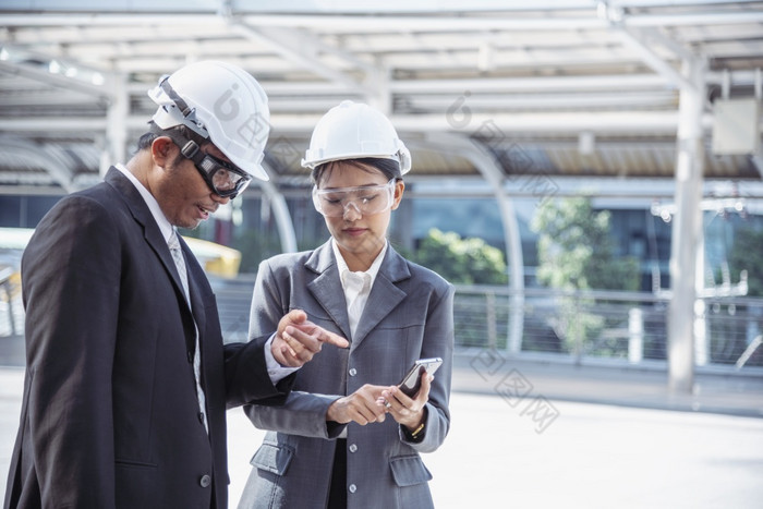 建设工程师安全西装信任团队持有白色黄色的安全硬他安全设备建设网站需要戴安全帽的保护头为民事建设工程师工程概念