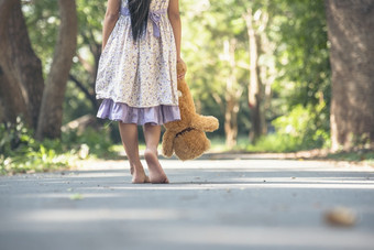 伤心女孩拥抱泰迪熊悲伤独<strong>自</strong>一人绿色花园公园孤独的女孩感觉伤心不开心走在户外与最好的朋友玩具<strong>自闭</strong>症孩子玩泰迪熊最好的朋友家庭暴力概念