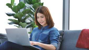 女人工作从首页移动PC在线会议首页办公室企业家亚洲业务女人使用笔记本移动PC坐沙发技术新正常的生活方式快乐女人打字键盘移动PC