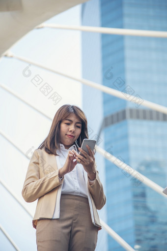 业务女人使用智能手机购物在线调用发短信消息互联网技术生活方式亚洲女人使用手机走城市街聪明的电话聪明的自信女人现代城市