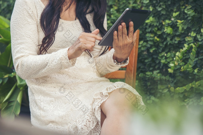 亚洲女人使用数字平板电脑购物在线调用发短信消息互联网技术生活方式与微笑脸亚洲女人触摸聪明的平板电脑焦点手使用移动应用程序首页办公室