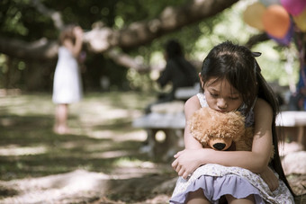 伤心女孩拥抱泰迪熊悲伤独<strong>自</strong>一人绿色花园公园孤独的女孩感觉伤心不开心坐着在户外与最好的朋友玩具<strong>自闭</strong>症孩子玩泰迪熊最好的朋友家庭暴力概念