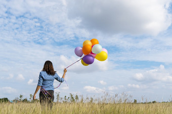 女人持有<strong>气球</strong>运行绿色草地白色云和蓝色的天空与幸福快乐的和放松手持有充满活力的空气<strong>气球</strong>玩生日聚会，<strong>派对</strong>快乐次夏天阳光户外