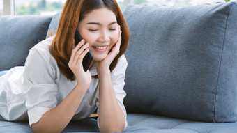 微笑脸亚洲女人持有智能手机与电子商务购物在线网站阅读在线<strong>文章博客</strong>视频<strong>博客</strong>年轻的女人手持有电话技术生活方式女人使用聪明的电话