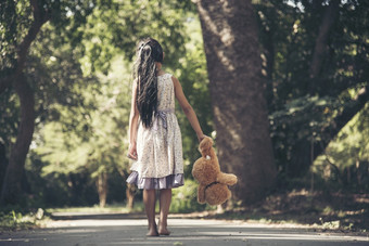 伤心女孩拥抱泰迪熊悲伤独自一人绿色花园公园孤独的女孩感觉伤心不开心走在户外与最好的朋友玩具自闭症孩子玩泰迪熊最好的朋友家庭暴力概念