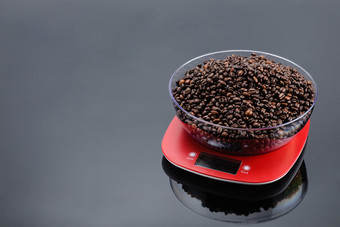咖啡豆子透明的碗红色的塑料电子规模灰色镜子背景复制空间咖啡豆子碗电子规模灰色镜子背景与复制空间