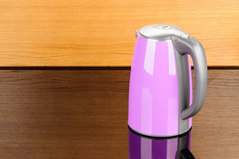 紫色的不锈钢钢孤立的无线电水壶与黑色的塑料处理的木镜子背景与复制空间紫色的孤立的不锈钢钢水壶的木镜子背景与复制空间