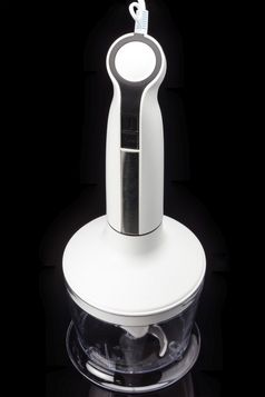 白色塑料电手搅拌机与黑色的按钮和附件的黑色的背景搅拌机与附件的黑色的背景