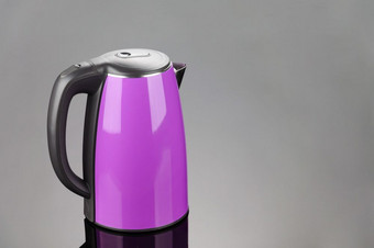 紫色的不锈钢钢孤立的无线电水壶与黑色的塑料处理的灰色镜子背景与复制空间紫色的孤立的不锈钢钢水壶的灰色镜子背景与复制空间