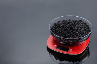 干黑莓透明的碗红色的塑料电子规模灰色镜子背景复制空间干黑莓碗电子规模灰色镜子背景与复制空间