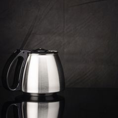不锈钢钢咖啡能与黑色的塑料成员的黑色的镜子背景复制空间咖啡能与黑色的成员孤立的的黑色的镜子背景复制空间
