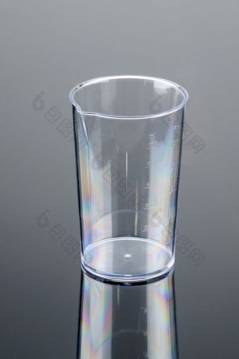 透明的测量玻璃为黑色的塑料电手搅拌机的灰色镜子背景复制空间透明的测量玻璃为搅拌机的灰色镜子背景