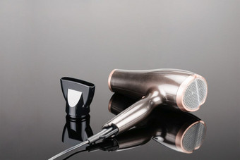 棕色（的）电手持头发干燥机为头发沙龙理发师商店的灰色镜子背景棕色（的）头发干燥机的灰色镜子背景