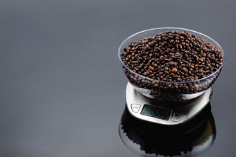 咖啡豆子透明的碗不锈钢钢电子规模灰色镜子背景复制空间咖啡豆子碗电子规模灰色镜子背景与复制空间