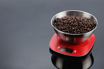咖啡豆子不锈钢钢碗红色的塑料电子规模灰色镜子背景复制空间咖啡豆子碗电子规模灰色镜子背景与复制空间