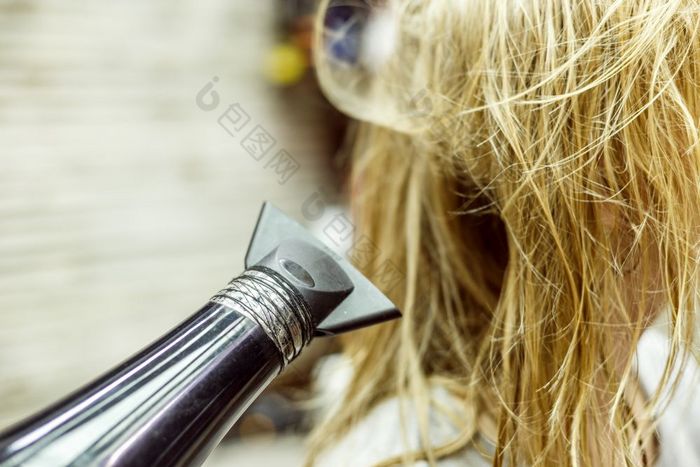 身份不明的金发女郎女人干湿头发与吹风机