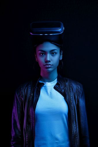 非裔美国人女孩眼镜与虚拟现实耳机孤立的黑色的背景照亮霓虹灯灯