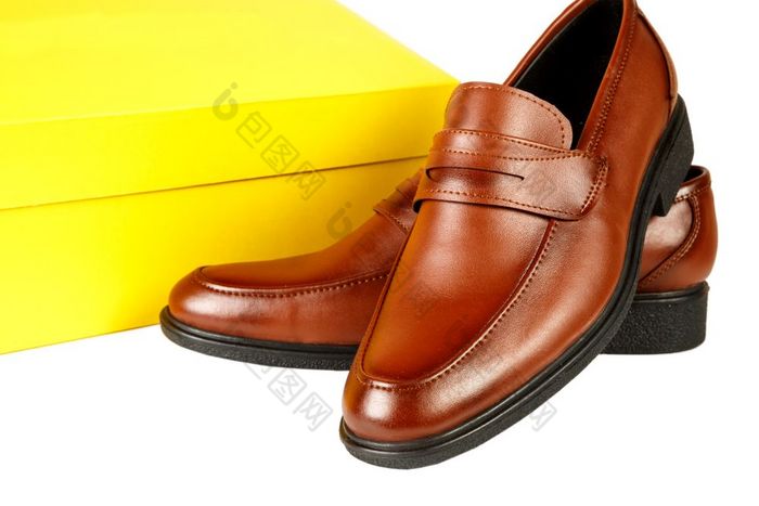 棕色（的）皮革鞋子与黄色的盒子白色孤立的背景