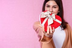 礼物盒子的形状心的手年轻的亚洲女孩粉红色的孤立的背景焦点的盒子