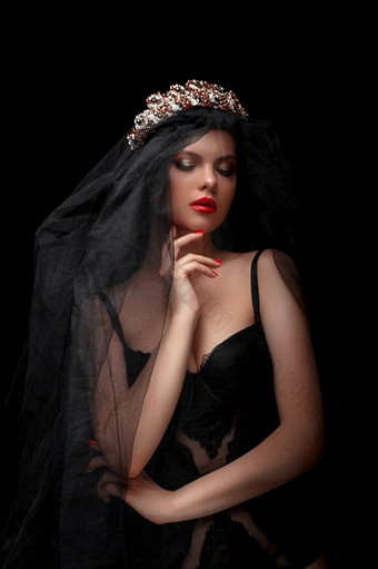年轻的美丽的女孩黑色的头巾和黑色的面纱黑色的孤立的背景
