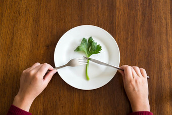 饮食概念一个<strong>绿色蔬菜</strong>空白色板与女人手芹菜木表格健康的前视图饮食概念一个<strong>绿色蔬菜</strong>空白色板与女人手芹菜木表格健康的