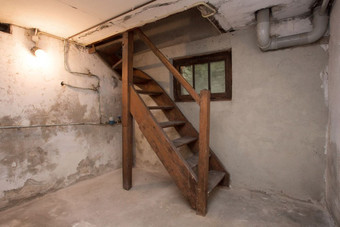 空地下室被遗弃的老工业建筑与小光和木楼梯黑暗空地下室被遗弃的老工业建筑与小光和木楼梯