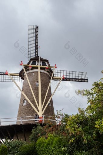 传统的荷兰风车的荷兰特写镜头与绿色树传统的荷兰风车的荷兰特写镜头