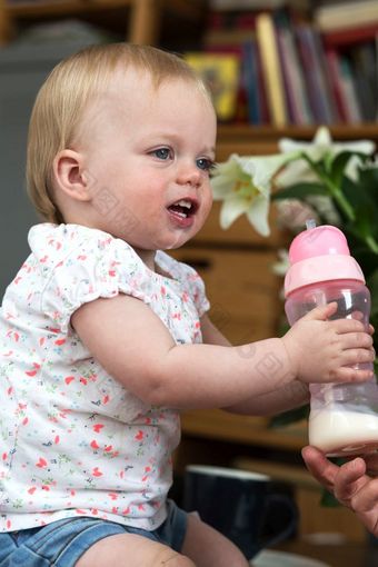 孩子喝牛奶从瓶可爱的和可爱的婴儿肖像孩子喝牛奶从瓶可爱的和可爱的婴儿