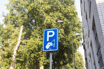 支付停车区域标志支付服务背景绿色树的城市特写镜头支付停车区域标志支付服务背景绿色树的城市