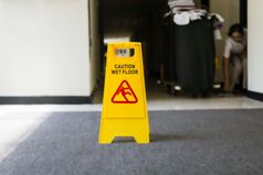 标志显示警告谨慎湿地板上更清洁的的背景黄色的标志显示警告谨慎湿地板上更清洁的的背景