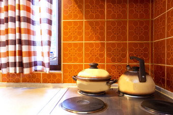原始古董厨房中间类与橙色瓷砖和老炉子与厨房工具锅复古的原始古董厨房中间类与橙色瓷砖和老炉子与厨房工具锅