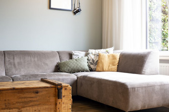 现代复古的光生活房间与灰色沙发和各种各样的彩色的枕头当前的趋势木盒子表格现代复古的光生活房间与灰色沙发和各种各样的彩色的枕头当前的趋势