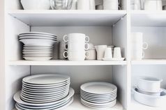 白色橱柜与白色陶器的厨房各种各样的清洁菜特写镜头白色橱柜与白色陶器的厨房各种各样的清洁菜