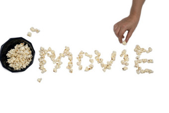 爆米花孤立的白色背景形成的词电影特写镜头与手持有爆米花爆米花孤立的白色背景形成的词电影与手持有爆米花