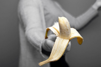 人持有黄色的香蕉水果手附近布莱克和白色背景给走了健康的概念特写镜头人持有黄色的香蕉水果手附近黑色的和白色背景给走了健康的概念
