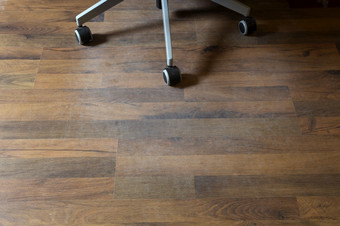 损坏的层压板地板上从办公室椅子轮子首页需要保护特写镜头损坏的层压板地板上从办公室椅子轮子首页需要保护