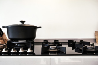 烹饪气体炉子与黑色的现代铁砂锅锅复古的设计特写镜头烹饪气体炉子与黑色的现代铁砂锅锅复古的设计