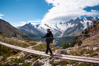 <strong>一个人</strong>年轻的男人。走悬架桥瑞士徒步旅行与美丽的景观旅行<strong>一个人</strong>年轻的男人。走悬架桥瑞士徒步旅行与美丽的景观