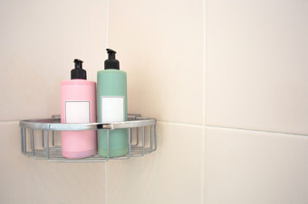 两个柔和的彩色的肥皂分配器淋浴架对<strong>平铺</strong>的墙现代设计与空白标签空间为文本两个柔和的彩色的肥皂分配器淋浴架对<strong>平铺</strong>的墙现代设计与空白标签