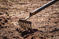 花园工作耙的地面挖掘rping土壤与耙的花园园艺农业播种概念特写镜头花园工作耙的地面挖掘rping土壤与耙的花园园艺农业播种概念