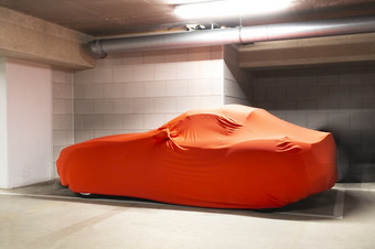 昂贵的新车与橙色封面为保护<strong>停车库</strong>现代体育车