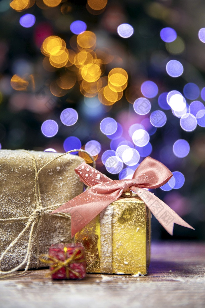 快乐圣诞节新一年礼物黄金盒子与粉红色的弓的雪散景圣诞节树背景与复制空间假期现在概念空间为文本快乐圣诞节新一年礼物黄金盒子与粉红色的弓的雪散景圣诞节树背景与复制空间假期现在概念