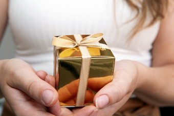 女人持有金礼物盒子手势给母亲一天圣诞节生日现在概念柔和的自然颜色背景休闲女人持有金礼物盒子手势给母亲一天圣诞节生日现在概念柔和的自然颜色背景