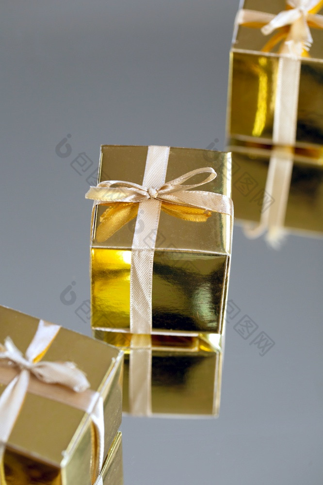 金礼物盒子与黄金丝带弓为生日圣诞节情人节一天母亲一天概念灰色的背景现在设计关闭金礼物盒子与黄金丝带弓为生日圣诞节情人节一天母亲一天概念灰色的背景现在设计