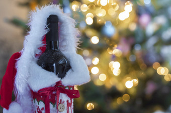 红色的酒和瓶与模糊散景灯圣诞节树背景圣诞节礼物假期现在概念与复制空间快乐圣诞节红色的酒和瓶与模糊散景灯圣诞节树背景圣诞节礼物假期现在概念与复制空间