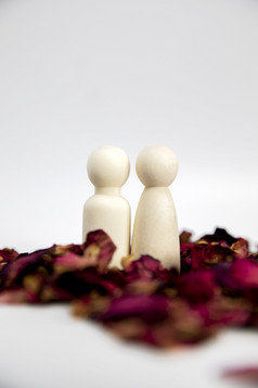 真正的爱情人夫妇概念两个木数据与红色的玫瑰花瓣白色背景站在一起孤立的白色背景复制空间空间为文本真正的爱情人夫妇概念两个木数据与红色的玫瑰花瓣白色背景站在一起孤立的白色背景复制空间