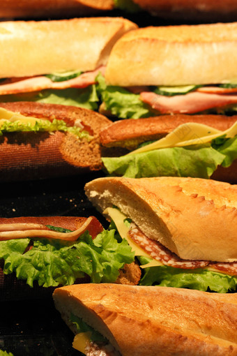 三明治使与新鲜的烤法国面包意大利蒜味腊肠培根奶酪和沙拉蔬菜